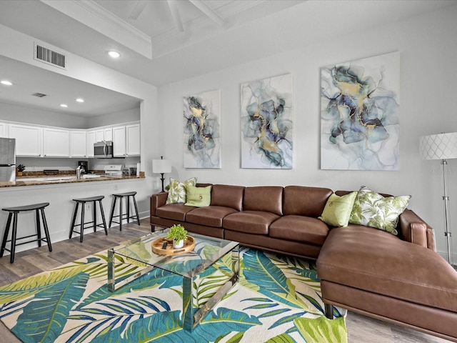 living room with beamed ceiling and light hardwood / wood-style floors