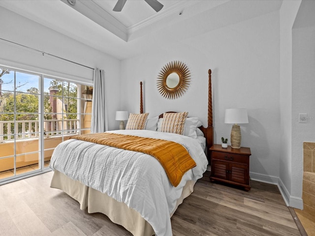 bedroom with a raised ceiling, crown molding, hardwood / wood-style flooring, ceiling fan, and access to exterior