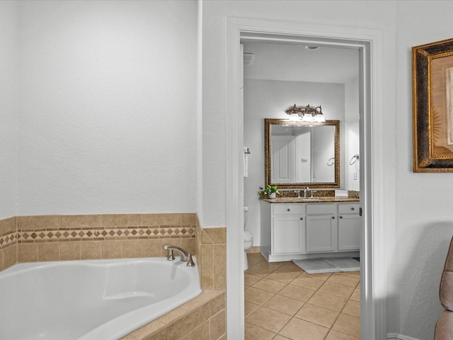 bathroom with tile patterned floors, vanity, tiled bath, and toilet