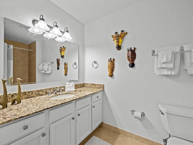 bathroom with tile patterned flooring, vanity, toilet, and walk in shower