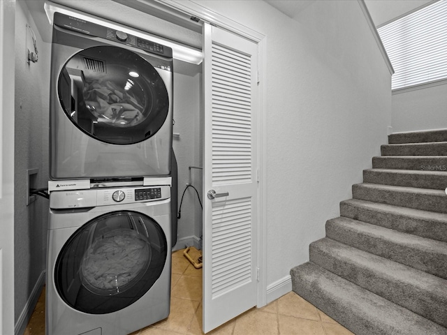 washroom featuring light tile patterned flooring and stacked washer and dryer