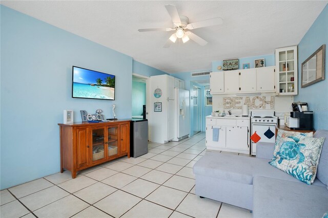 tiled living room featuring ceiling fan and sink