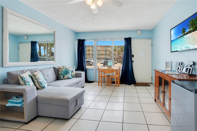 living room featuring light tile patterned flooring, ceiling fan, and a textured ceiling