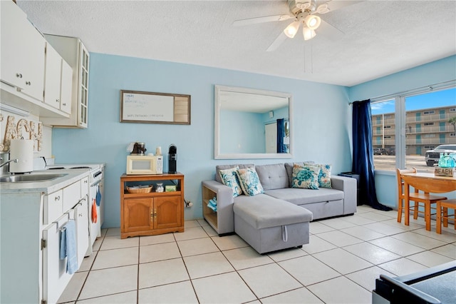 kitchen with white cabinets, sink, light tile patterned flooring, and ceiling fan