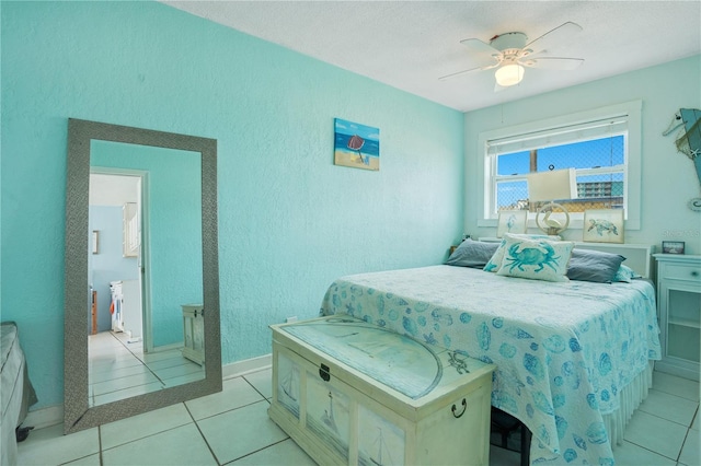 bedroom featuring a textured wall, ceiling fan, baseboards, and light tile patterned floors