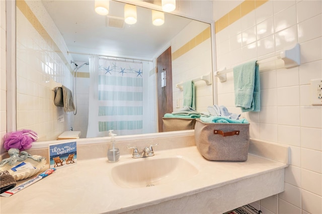 bathroom with tile walls, vanity, and a shower with shower curtain