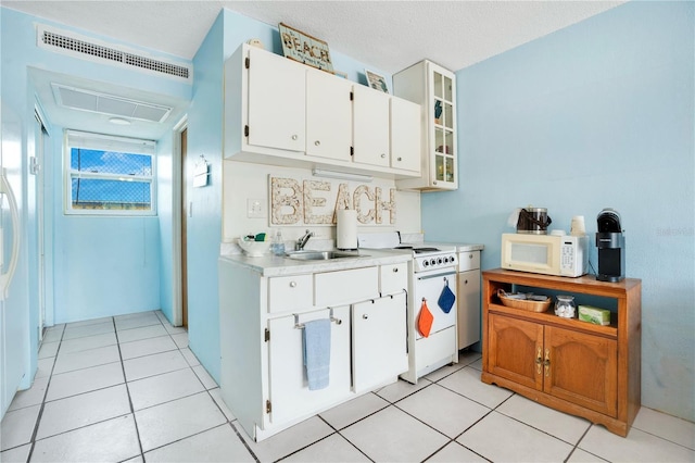 kitchen with light countertops, glass insert cabinets, white cabinetry, a sink, and white appliances