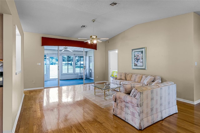 living room with ceiling fan, lofted ceiling, and hardwood / wood-style floors