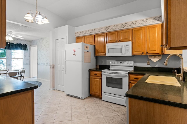 kitchen featuring decorative light fixtures, sink, ceiling fan with notable chandelier, white appliances, and light tile patterned flooring