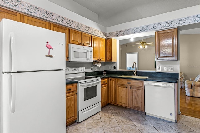 kitchen featuring sink, light wood-type flooring, lofted ceiling, white appliances, and ceiling fan