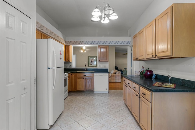 kitchen featuring sink, light wood-type flooring, white appliances, ceiling fan with notable chandelier, and pendant lighting