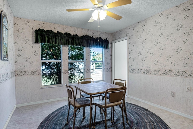 tiled dining room with ceiling fan and a textured ceiling