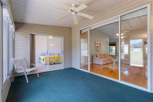 unfurnished sunroom with ceiling fan and lofted ceiling