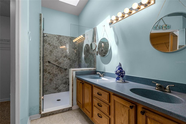 bathroom featuring tiled shower, a skylight, tile patterned flooring, and vanity