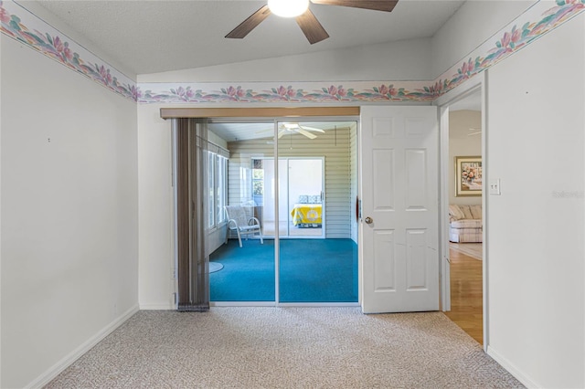 unfurnished bedroom featuring carpet floors, lofted ceiling, a closet, and ceiling fan