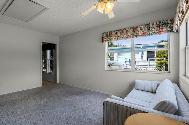 carpeted living room with a textured ceiling and ceiling fan