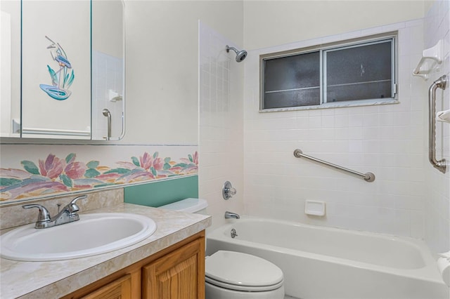 full bathroom featuring vanity, tiled shower / bath combo, and toilet