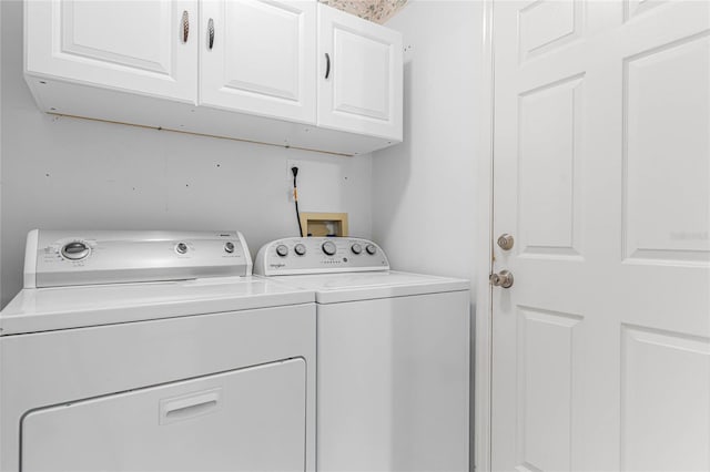 washroom featuring independent washer and dryer and cabinets