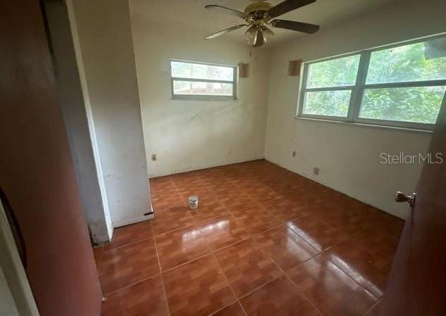 unfurnished bedroom featuring ceiling fan and dark tile patterned flooring