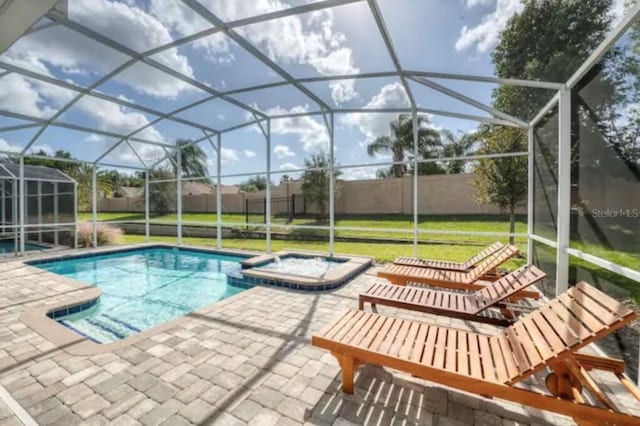 view of swimming pool featuring a lanai, a patio area, and an in ground hot tub