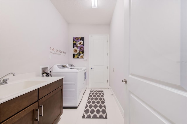 laundry room featuring light tile patterned floors, washing machine and clothes dryer, cabinets, and sink