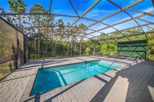 view of swimming pool with glass enclosure and a patio