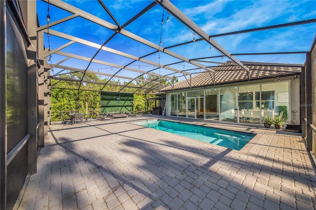 view of swimming pool with a lanai and a patio area