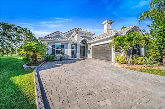 mediterranean / spanish-style home with a garage and a front yard