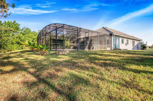 back of house featuring a yard and a lanai