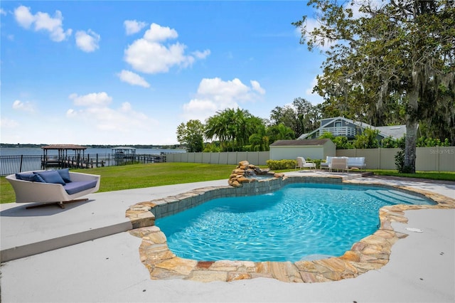 view of swimming pool with a fenced in pool, a storage unit, a lawn, a fenced backyard, and an outdoor structure