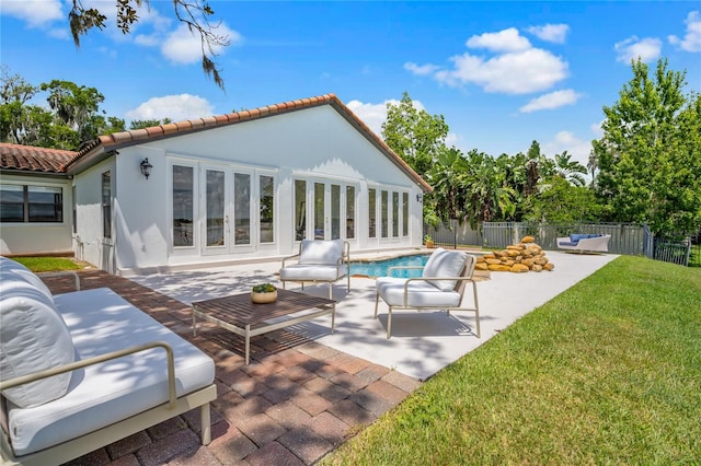 back of house featuring a lawn, a fenced in pool, a patio, and french doors