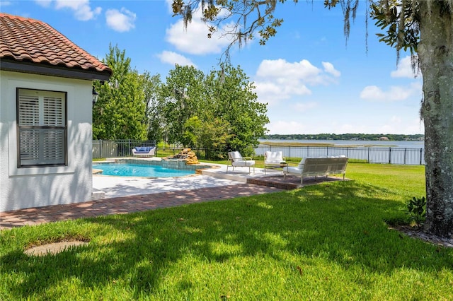 view of swimming pool with a water view, a lawn, and a patio