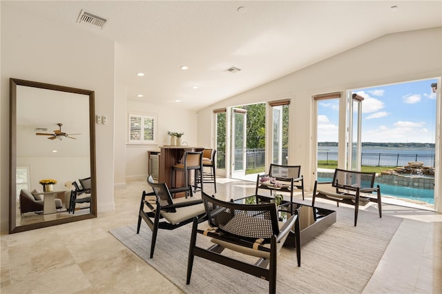 dining space featuring lofted ceiling, ceiling fan, and a water view