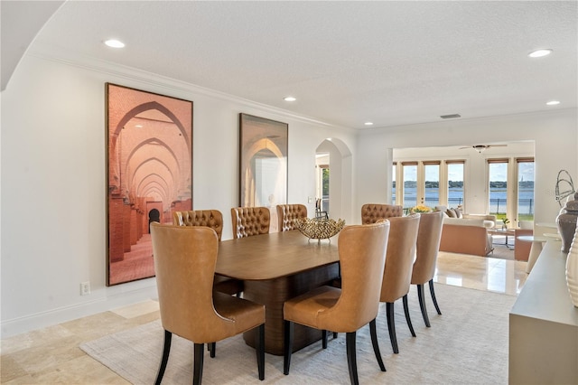 dining room with visible vents, ornamental molding, and arched walkways