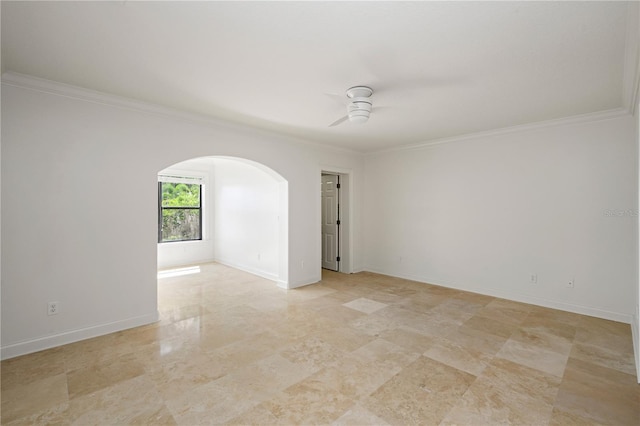 empty room featuring arched walkways, baseboards, a ceiling fan, and crown molding