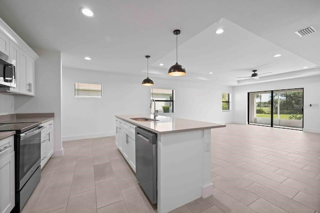 kitchen featuring stainless steel appliances, sink, an island with sink, white cabinets, and ceiling fan