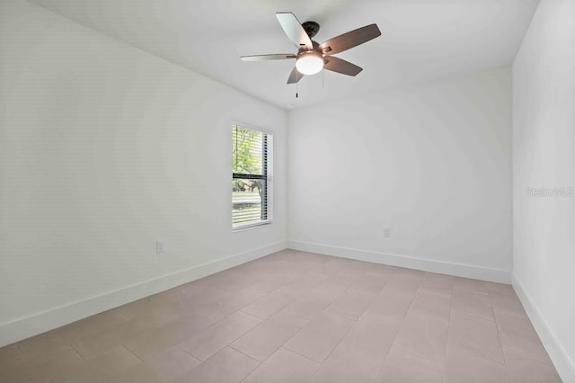 empty room with a ceiling fan and baseboards