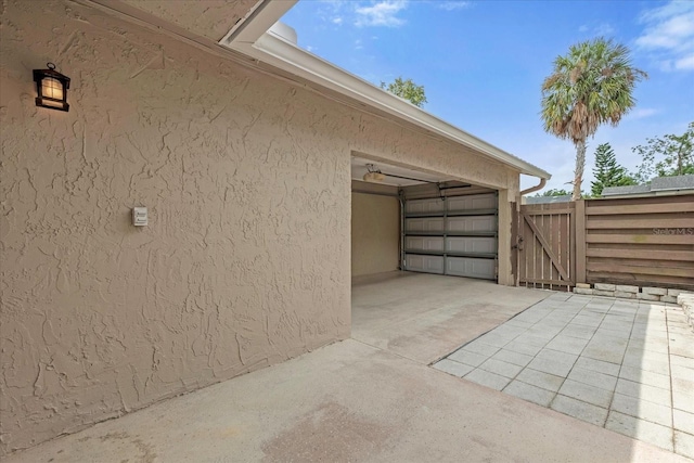 view of property exterior with a garage, a gate, and stucco siding