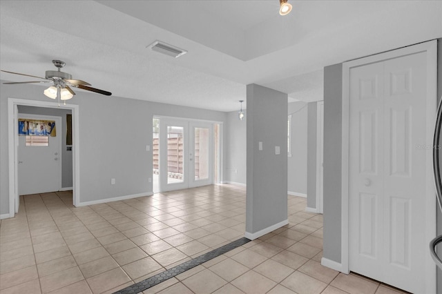 tiled spare room with ceiling fan and french doors