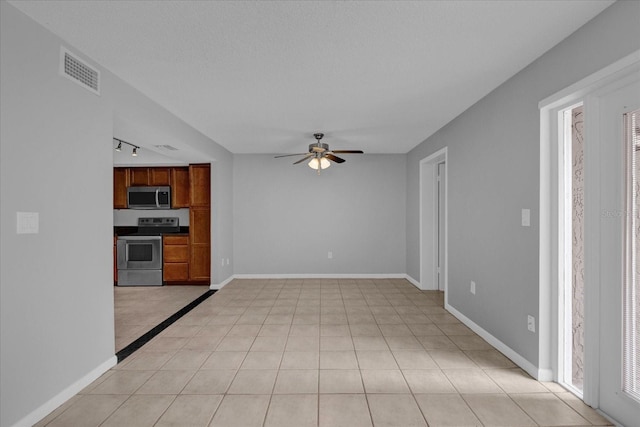 kitchen with brown cabinets, stainless steel appliances, visible vents, a ceiling fan, and baseboards