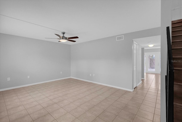 empty room featuring a ceiling fan, visible vents, and baseboards