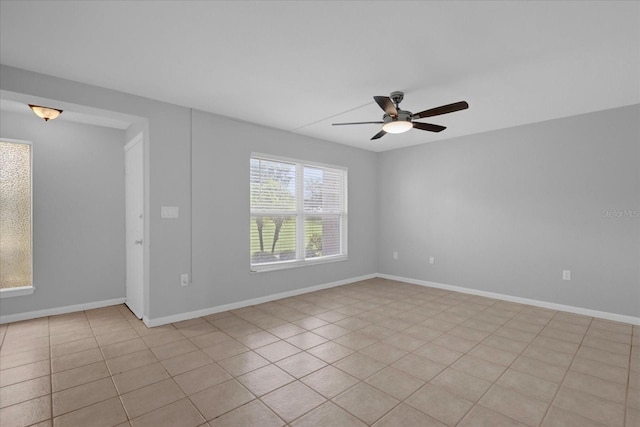 unfurnished room featuring a ceiling fan and baseboards