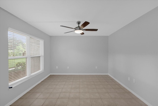 spare room with ceiling fan and light tile patterned floors