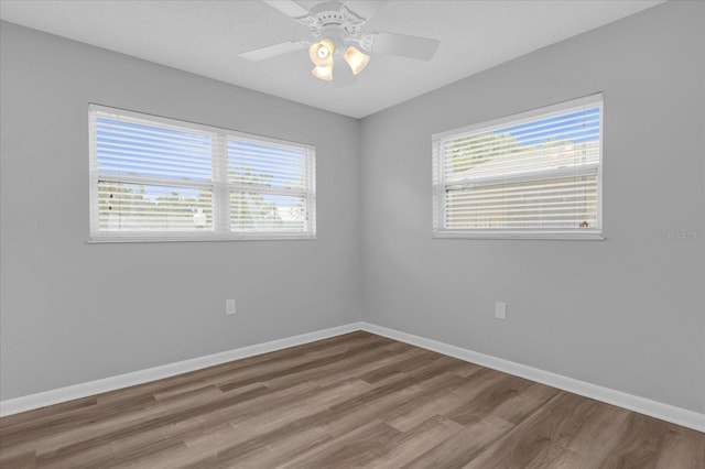 unfurnished room with ceiling fan, baseboards, and wood finished floors