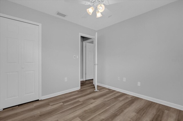 unfurnished bedroom with a closet, ceiling fan, and hardwood / wood-style floors