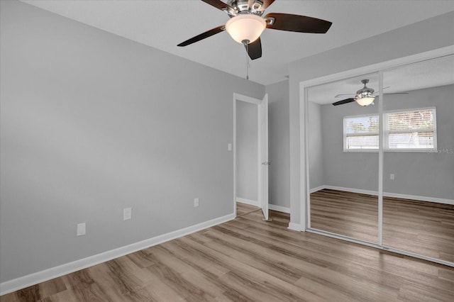 unfurnished bedroom featuring a ceiling fan, a closet, baseboards, and wood finished floors