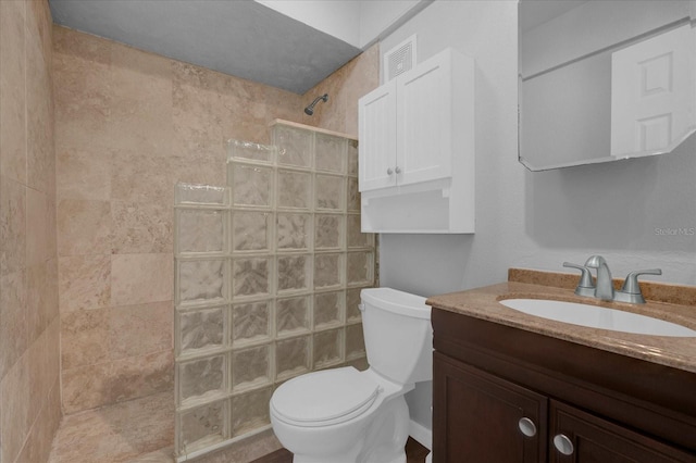 bathroom with toilet, walk in shower, and vanity