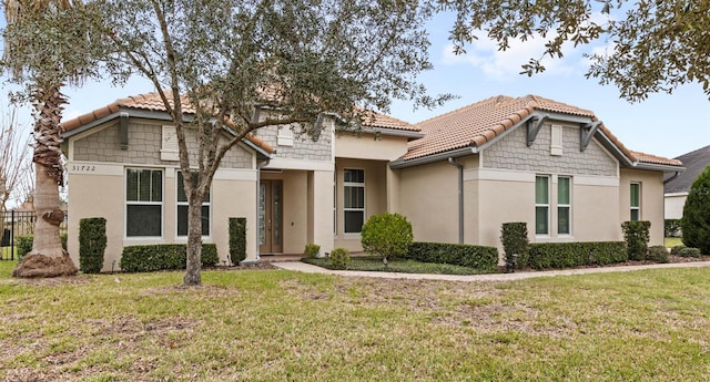 mediterranean / spanish house featuring a front lawn