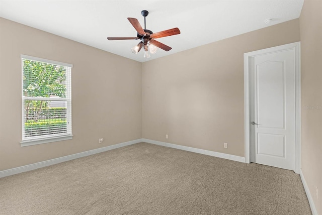 carpeted spare room with ceiling fan