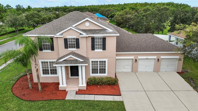 view of front property featuring a garage and a front yard